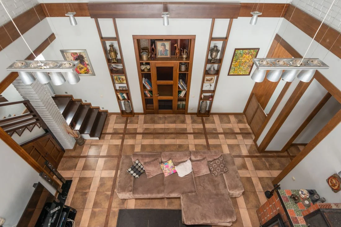 Living room viewed from above with a freestanding sofa and bookshelves