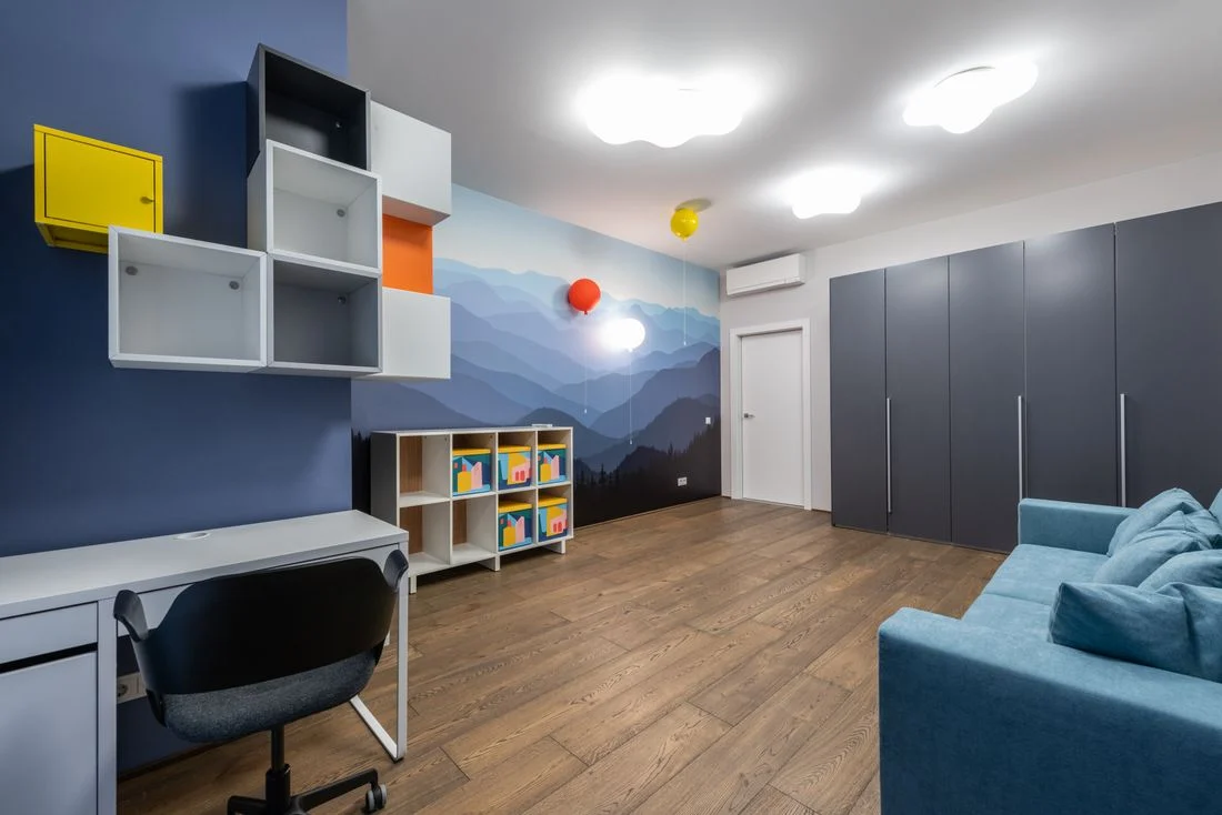 Multipurpose room with a blue sofa, desk, and colorful storage cubes