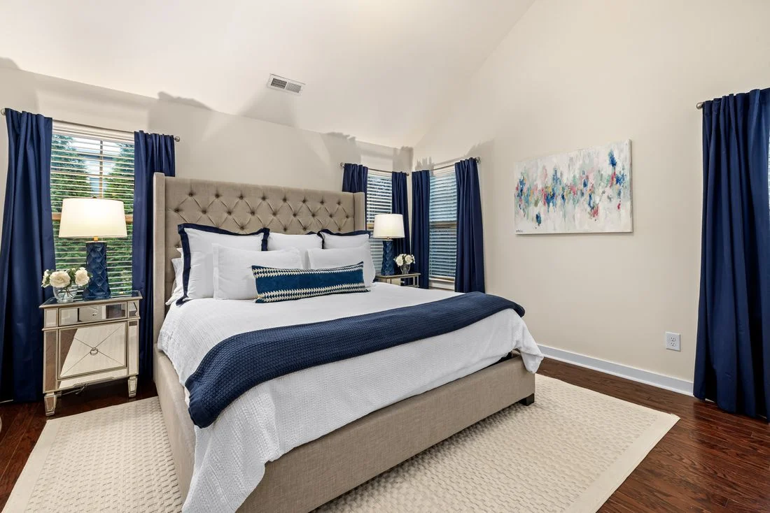 Blue and white bed with a rug extending beyond its sides