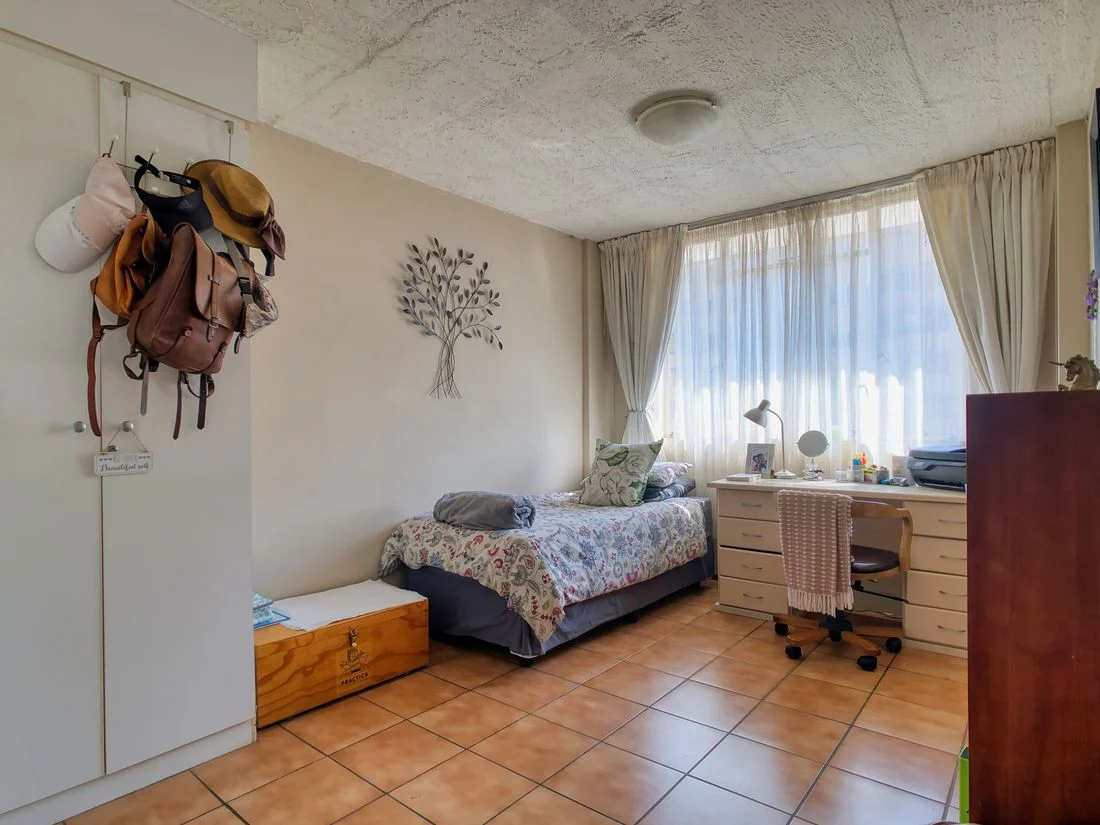 Guest bedroom with a single bed and wooden desk