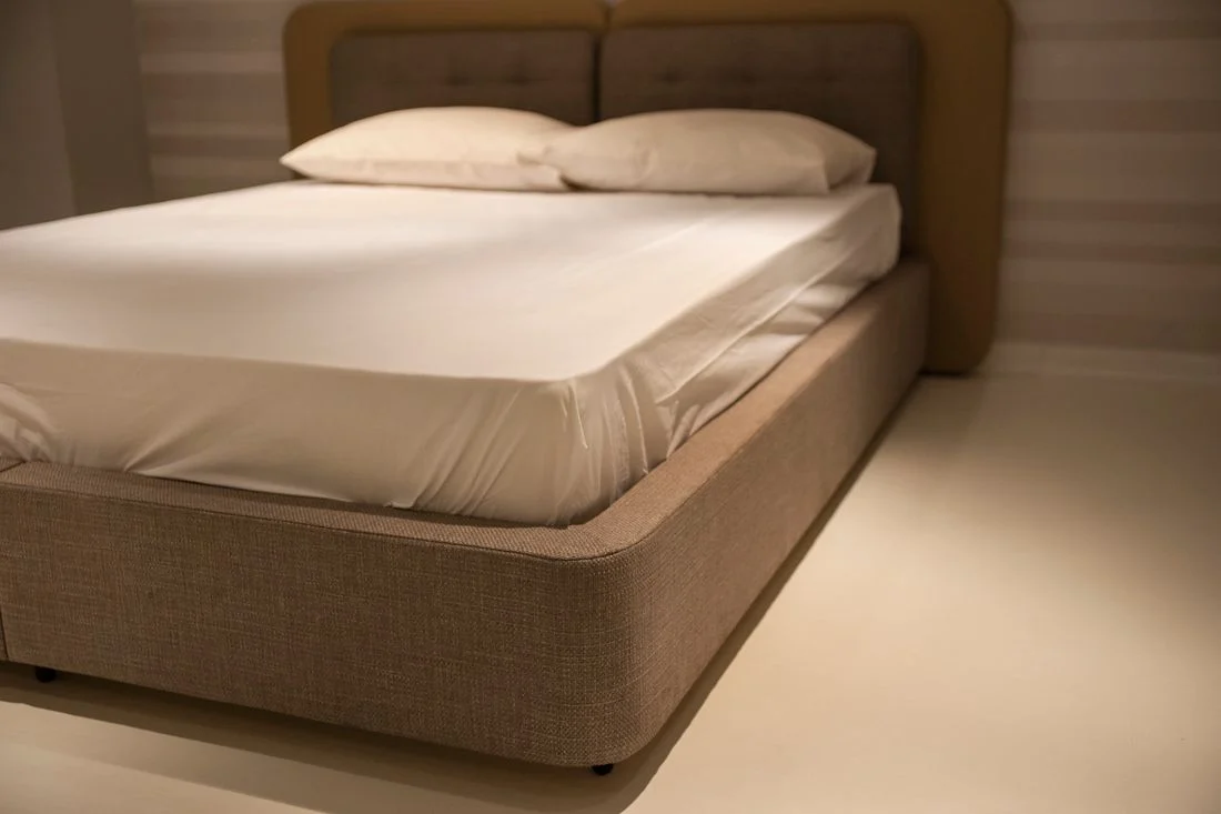 White fitted sheet on a mattress with white pillows