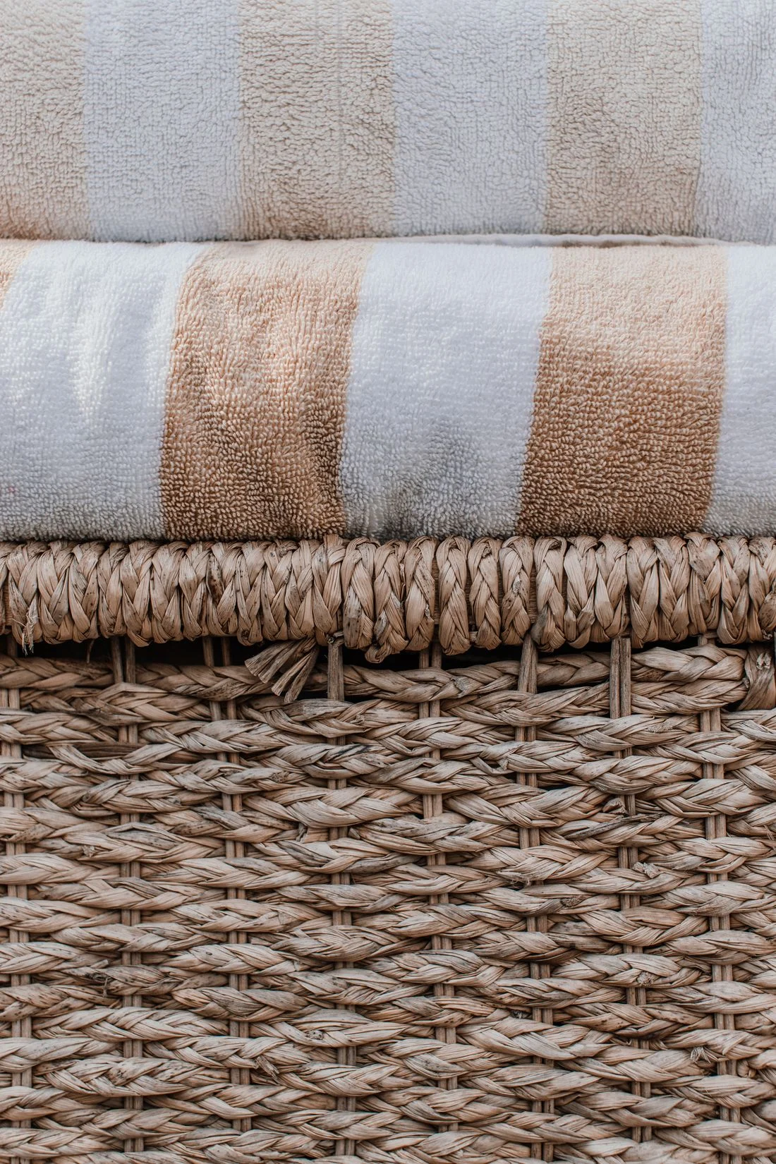 Folded striped towels on a wicker basket