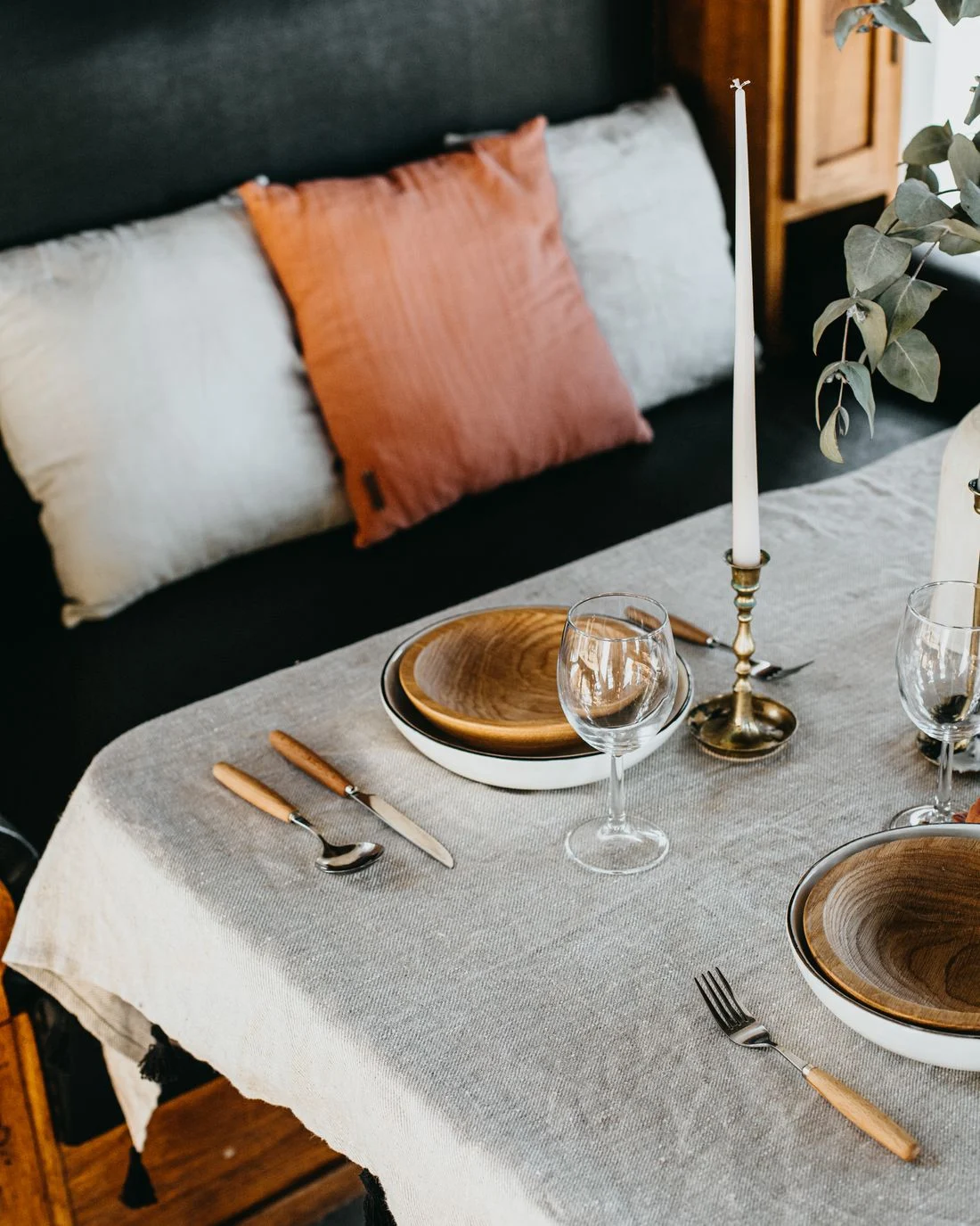 Dining table arranged with greenery and tableware
